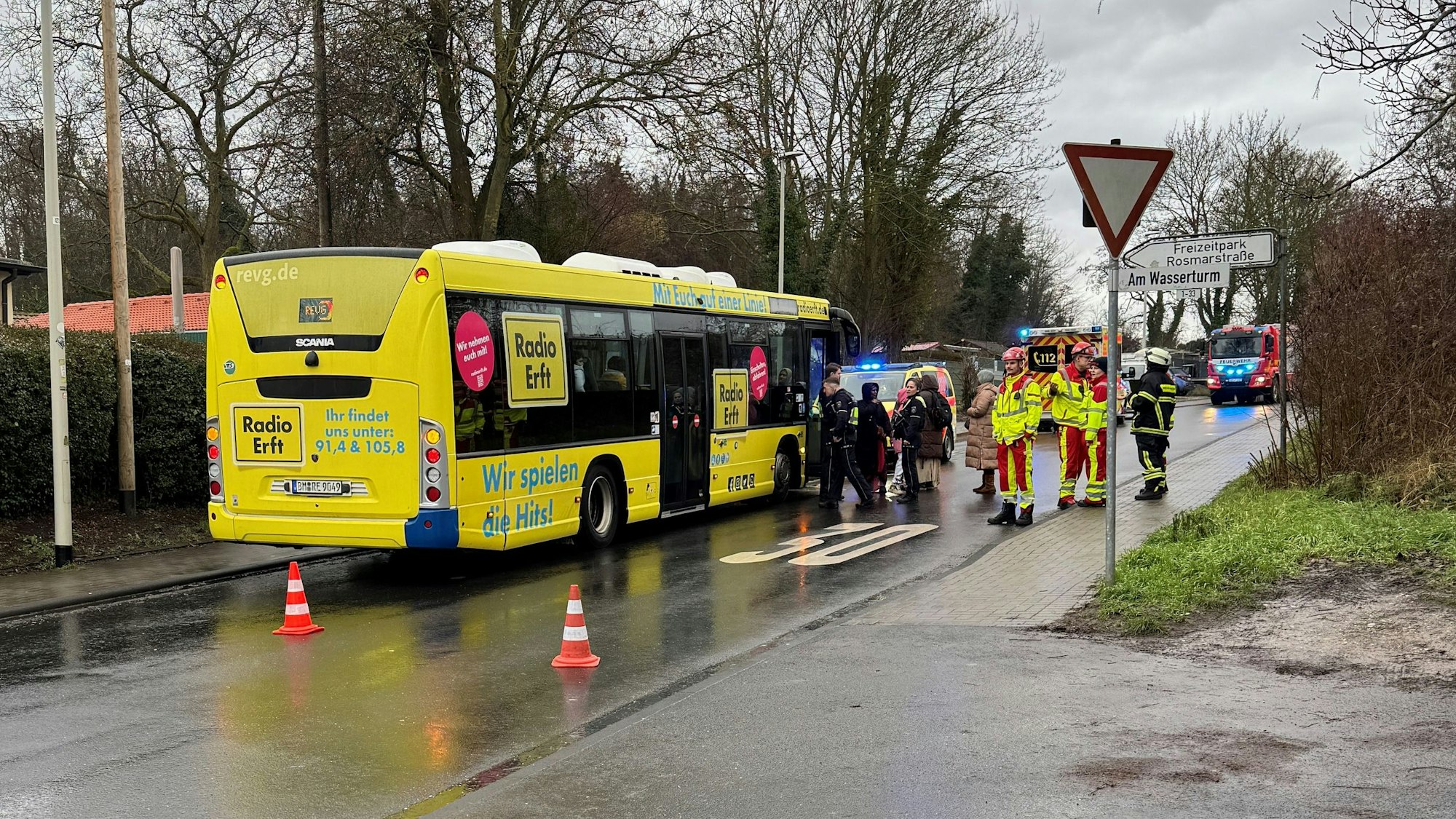 Das Bild zeigt mehrere Personen an einem Bus.