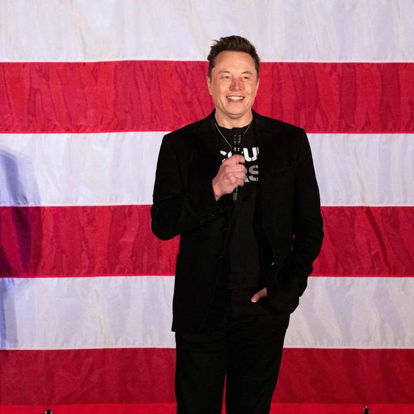 Elon Musk steht vor einer US-Flagge.