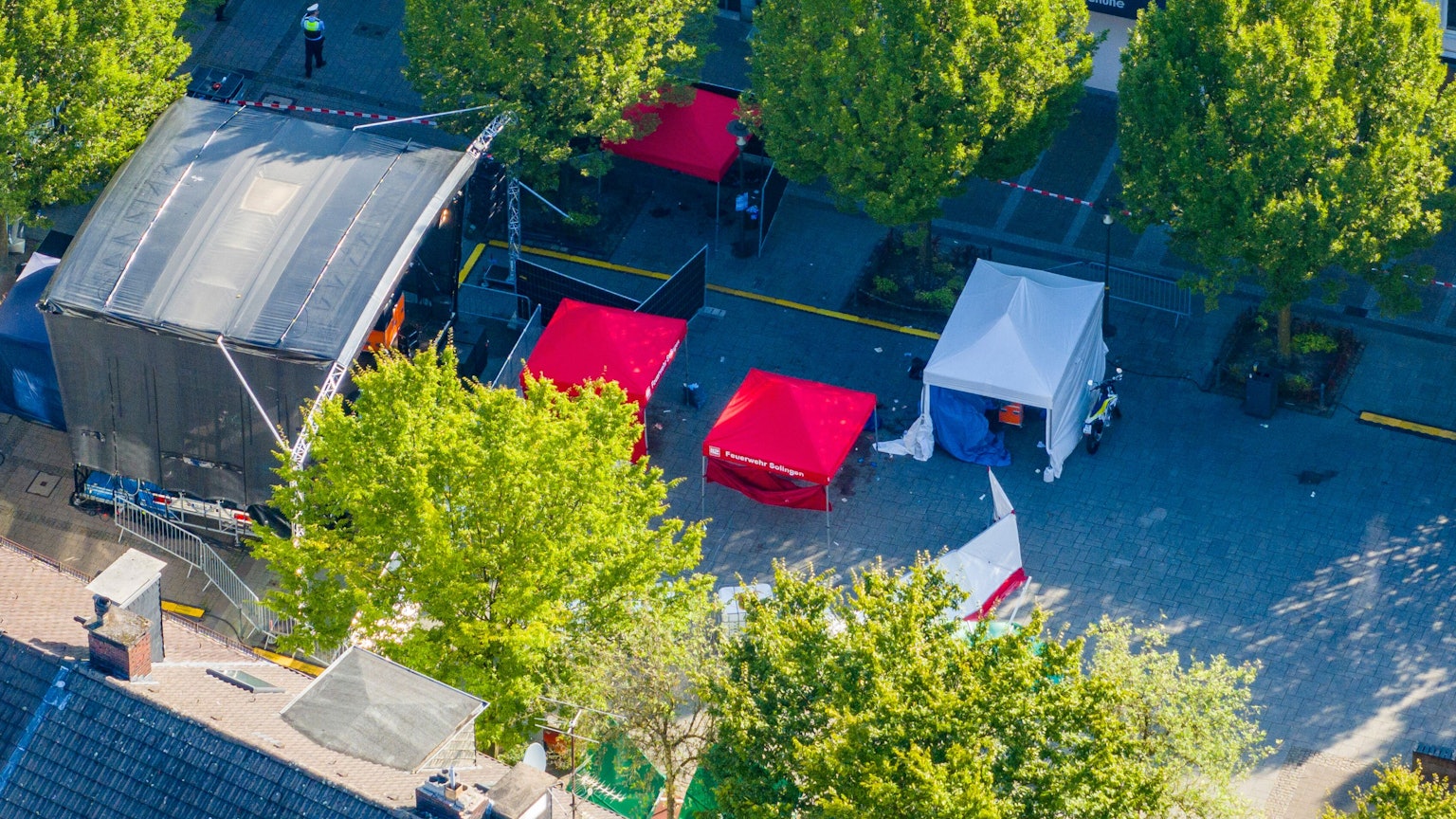 Nach der Messerattacke auf dem Solinger Stadtfest stehen am Samstagmorgen Zelte von Polizei und Feuerwehr am Tatort vor der Bühne auf dem Fronhof in der Solinger Innenstadt. Die Polizei löste Großalarm aus.