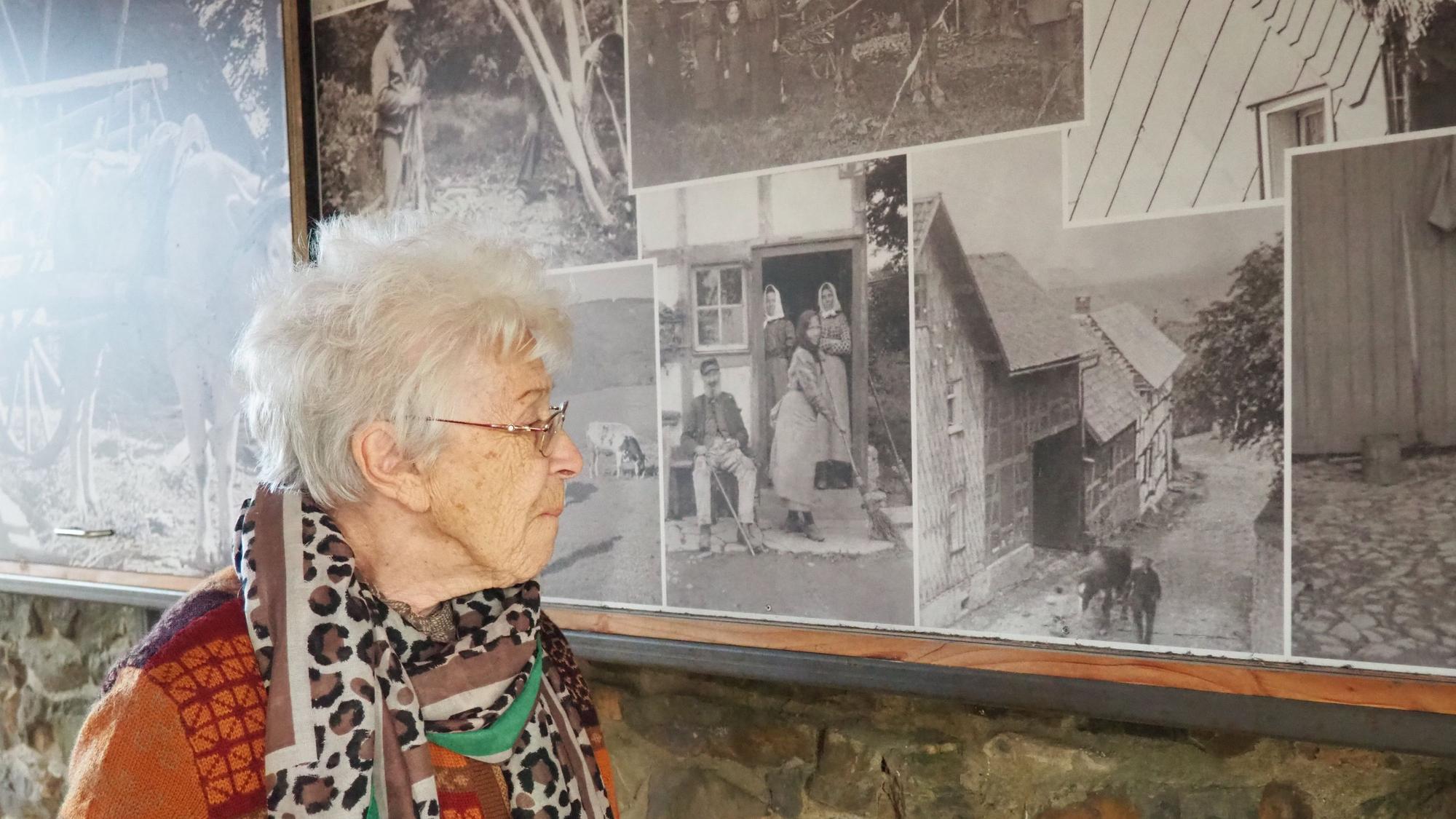 Christel Küpper blickt auf die großformatigen historischen Fotos an einer Wand in der alten Schule.