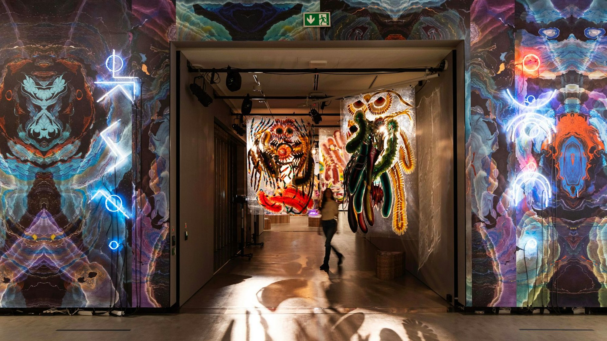 Eine Frau steht zwischen tapezierten Wänden.