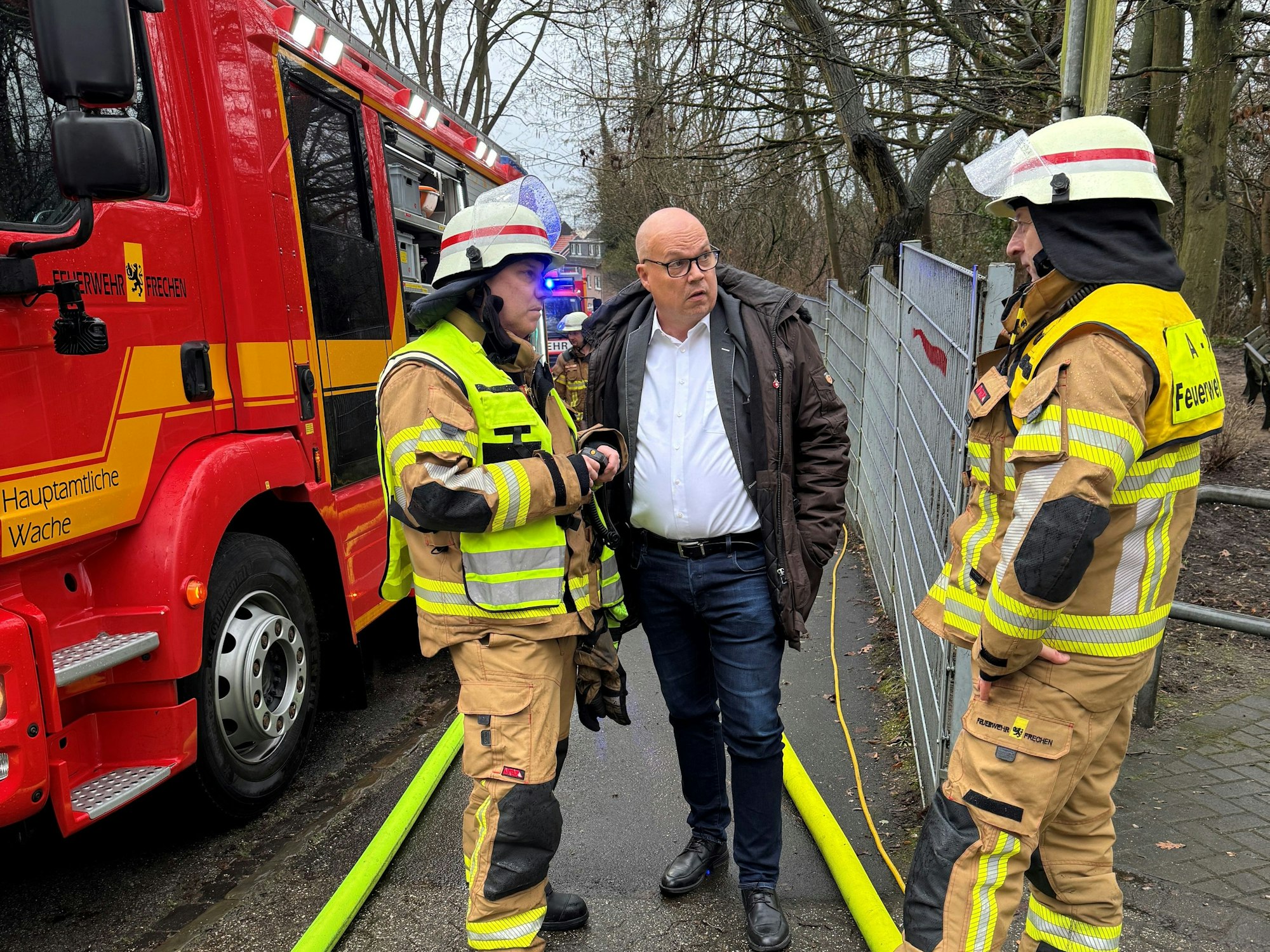 Das Bild zeigt Bürgermeister Uwe Tietz im Gespräch mit zwei Feuerwehrmännern.