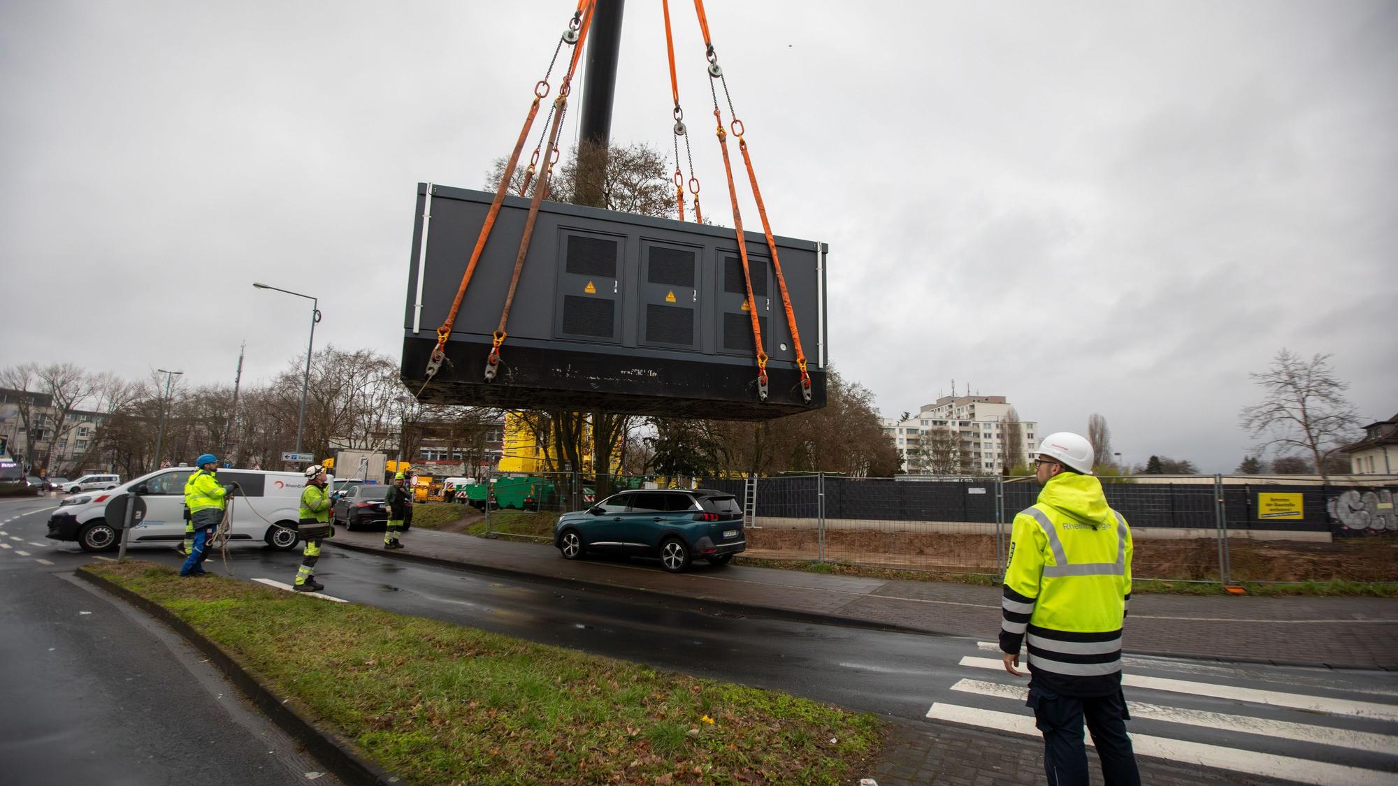 Mit einem Schwerlastkran werden Gebäudeteile für eine Trafostation in Porz transportiert.