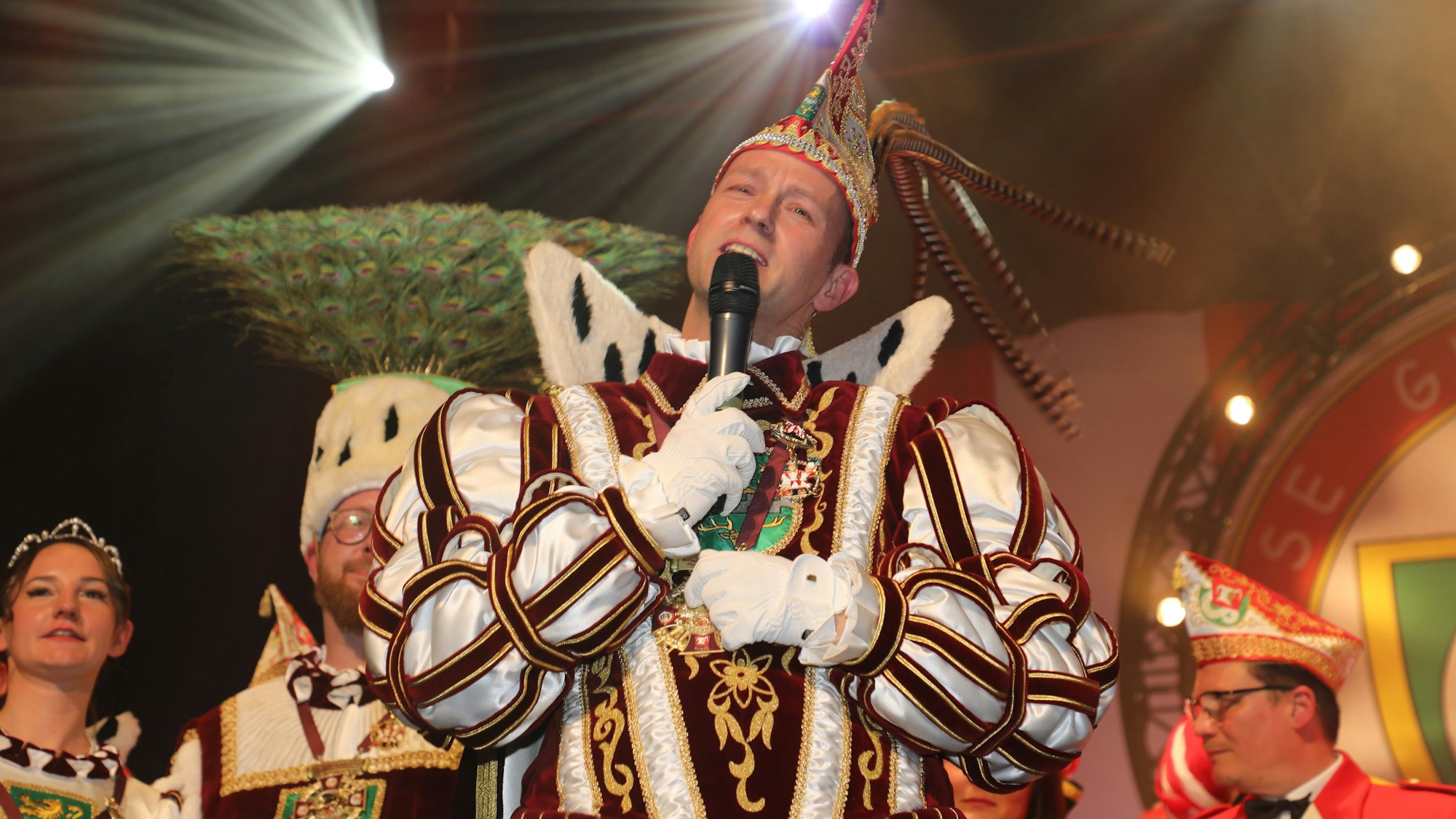 Prinz Thomas III: (Schmitz) singt bei der Proklamtion. Im Hintergrund stehen Bauer Maurice (Jakobs) und Jungfrau Lea (Rodenbach)