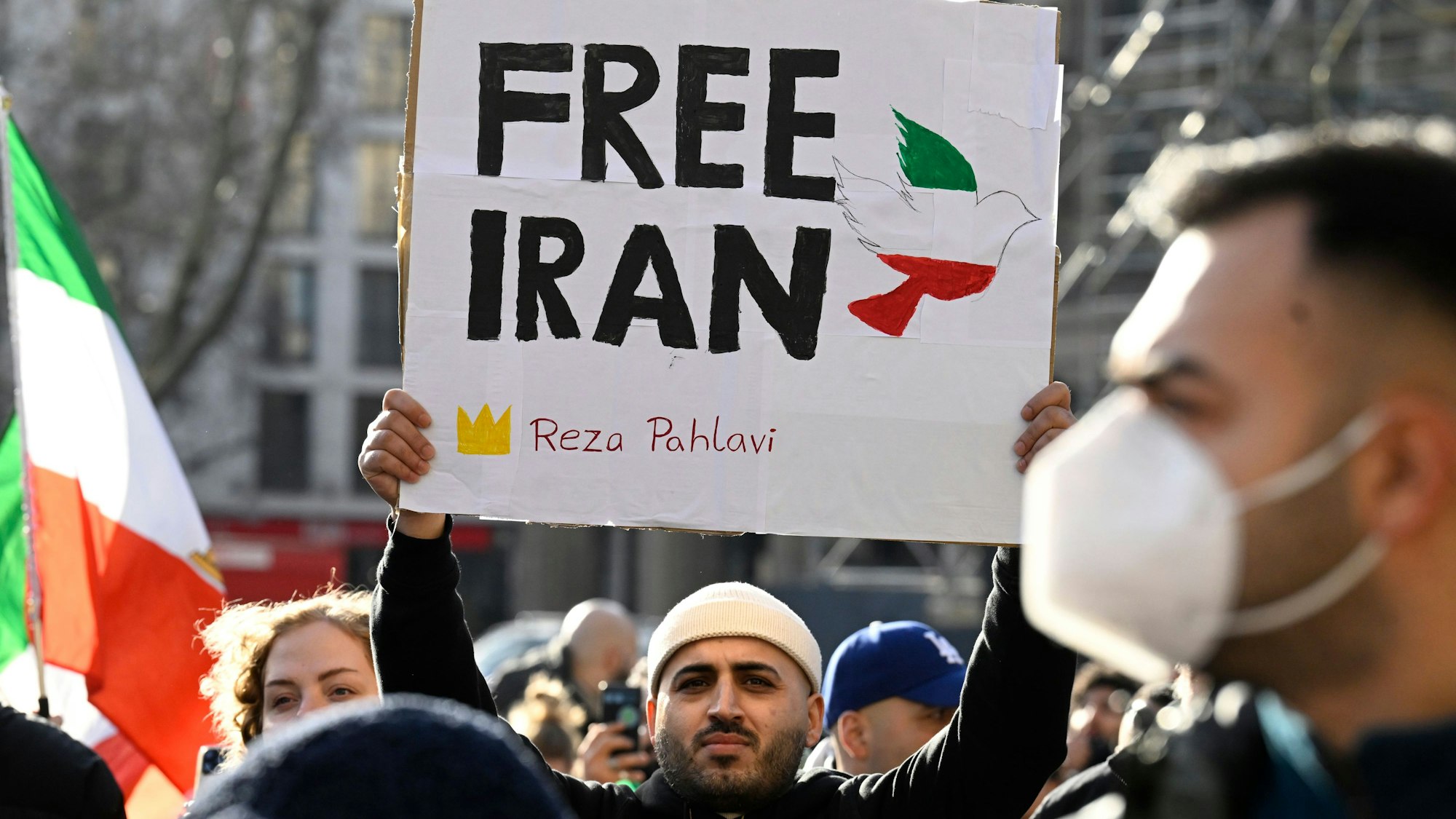 Ein Demo-Teilnehmer hält ein Schild mit der Aufschrift „Free Iran“ hoch.