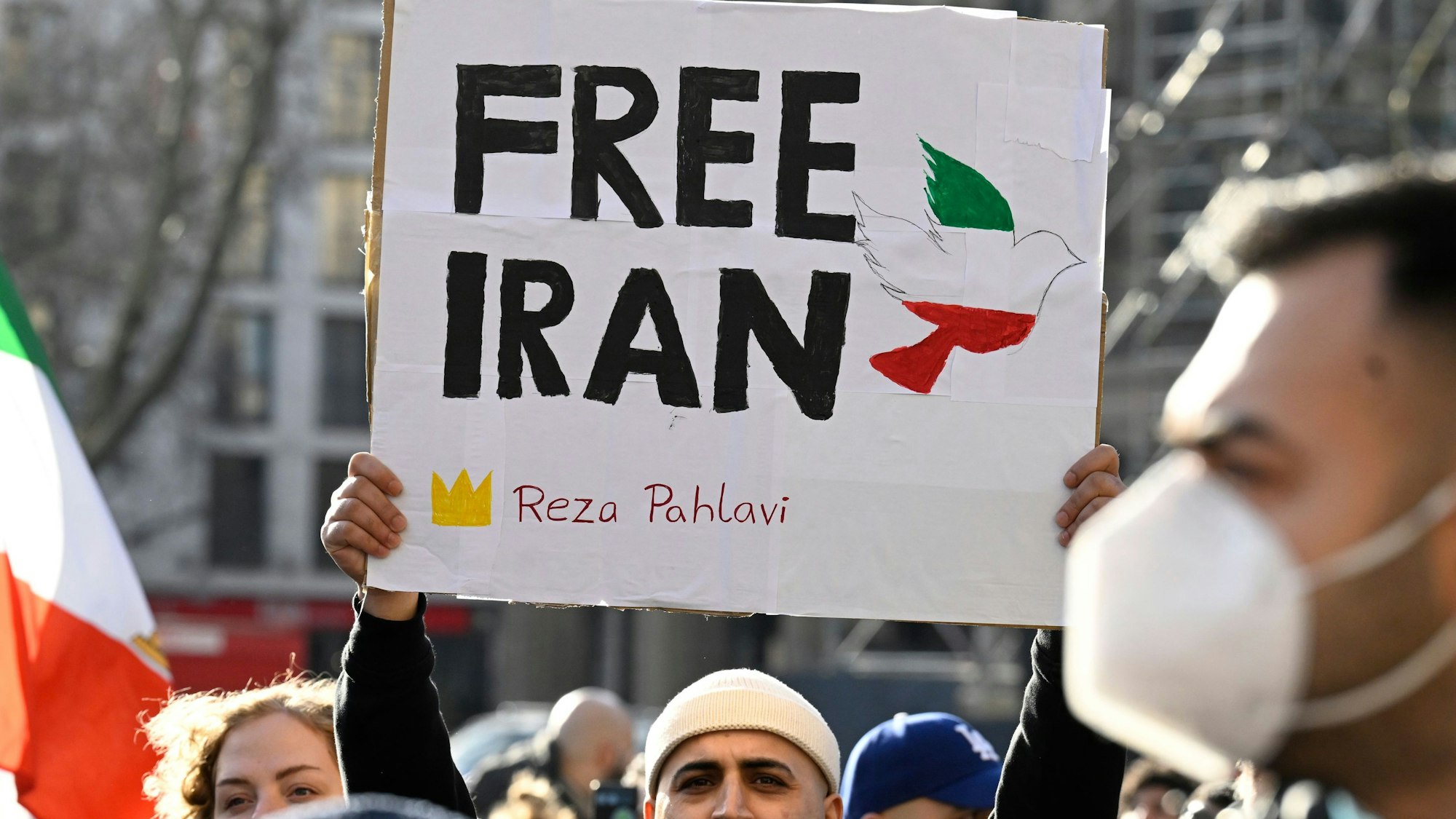 Ein Teilnehmer hält bei einer Demonstration ein Schild mit der Aufschrift Free Iran hoch.
