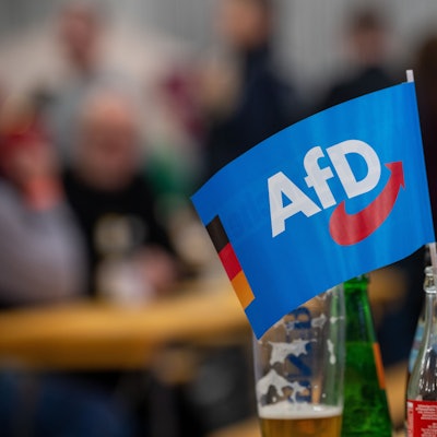 Ein Fähnchen der Alternative für Deutschland (AfD) steckt in einer Flasche bei einer Veranstaltung. (Symbolfoto)