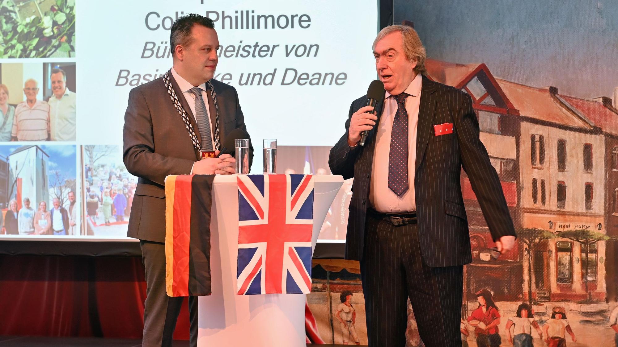 Das Bild zeigt die beiden Bürgermeister im Gespräch auf der Bühne.