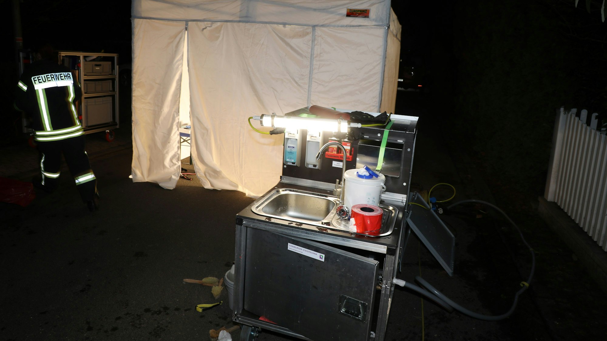 Vor einem auf der Straße Wiedenhof in Rösrath-Forsbach aufgebauten Zelt steht ein mobiles Waschbecken.
