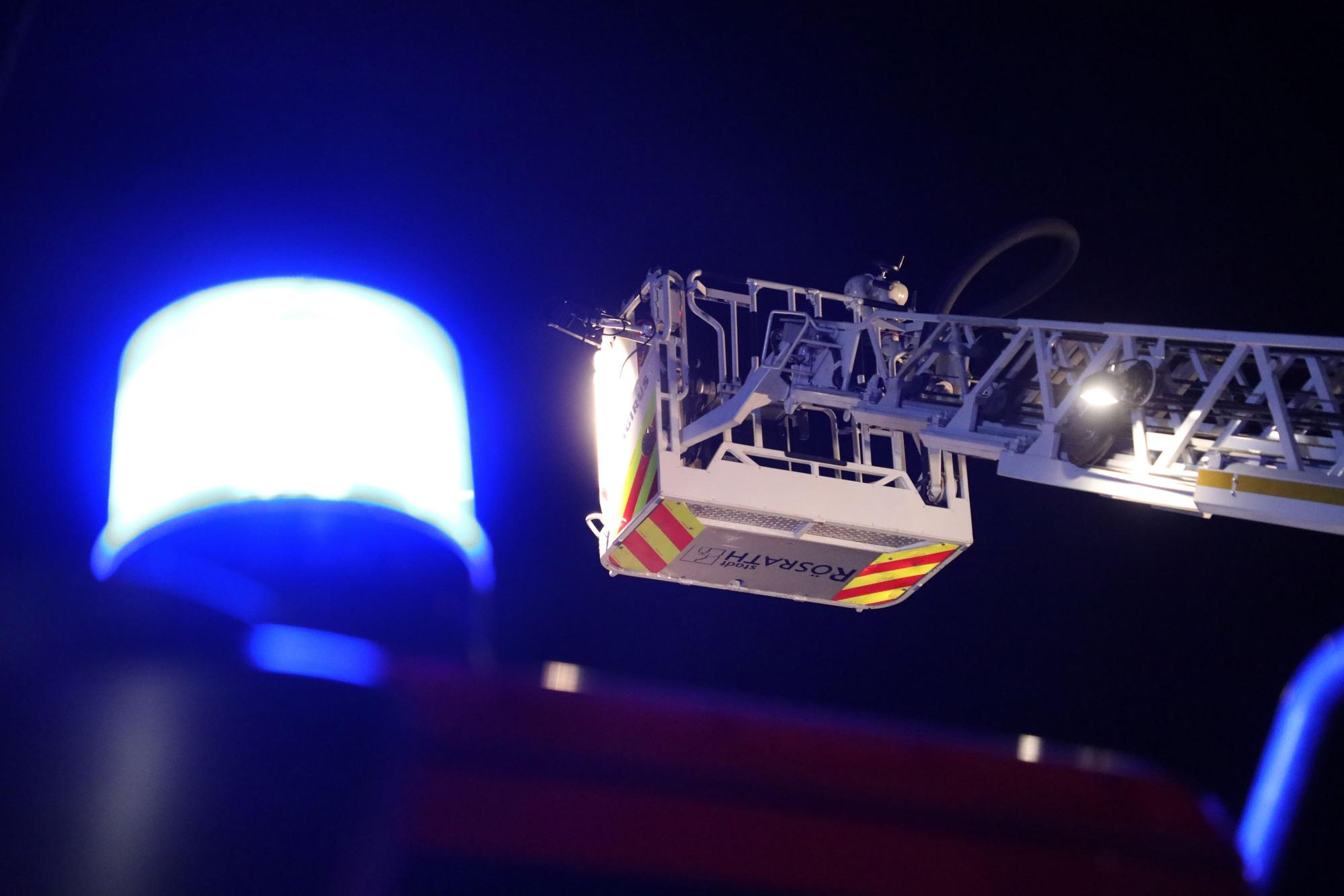 Neben einem Blaulicht ist der Korb der Drehleiter der Feuerwehr Rösrath zu sehen.