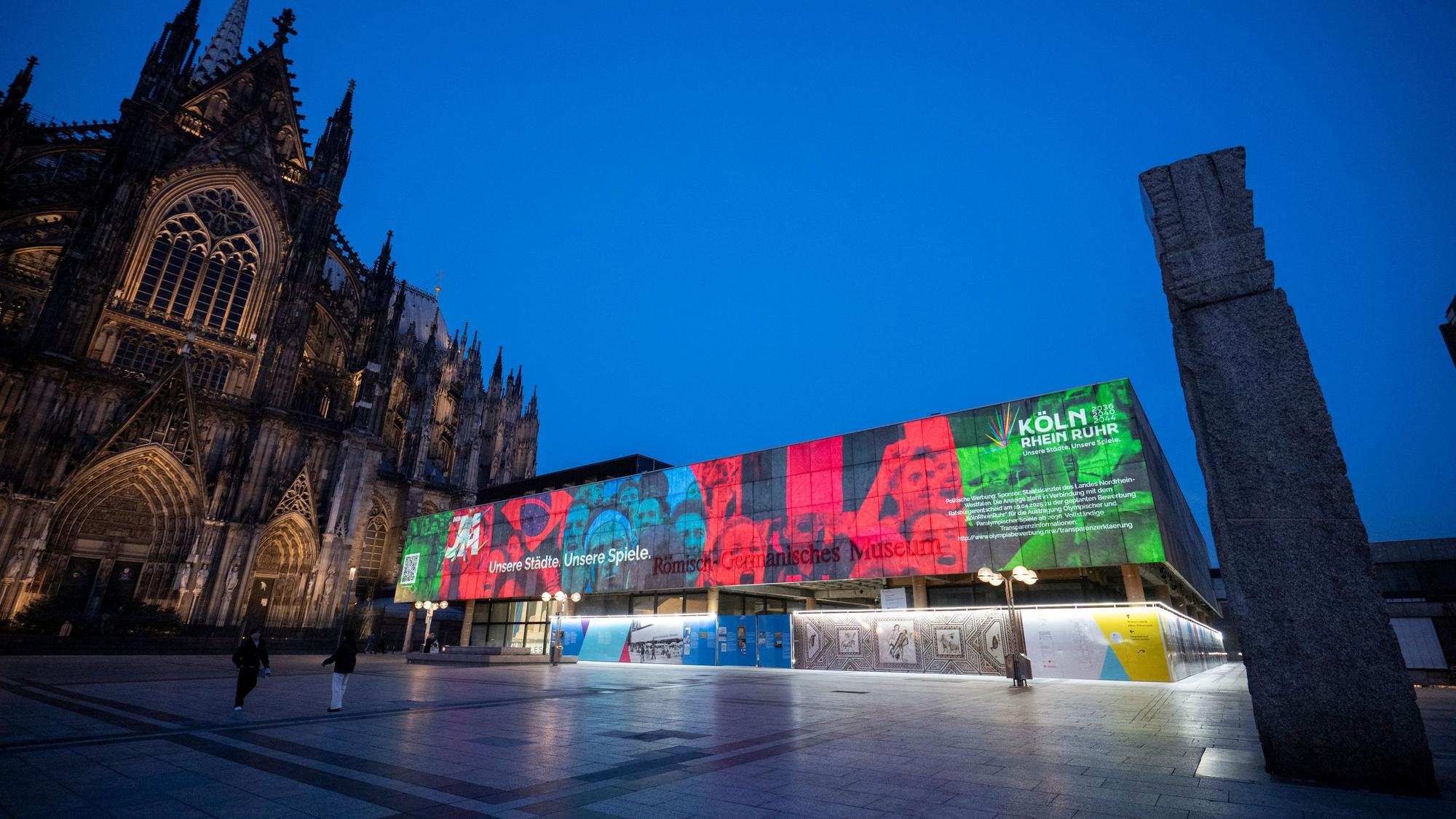 Mit einer Lichtinstallation am Römisch-Germanischen-Museum wirbt die Landesregierung für ihre Olympia-Kampagne. Zeitgleiche Aktionen an markanten Orten in NRW sollen die Bevölkerung von der Bewerbung für die Olympischen und Paralympischen Spiele überzeugen.