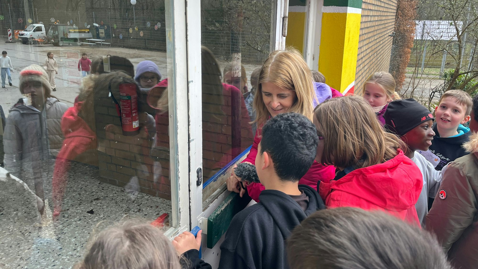 Reporterin Christina Pannhausen schaut mit Viertklässlern in das geschlossene OGS-Gebäude der Astrid-Lindgren-Schule
