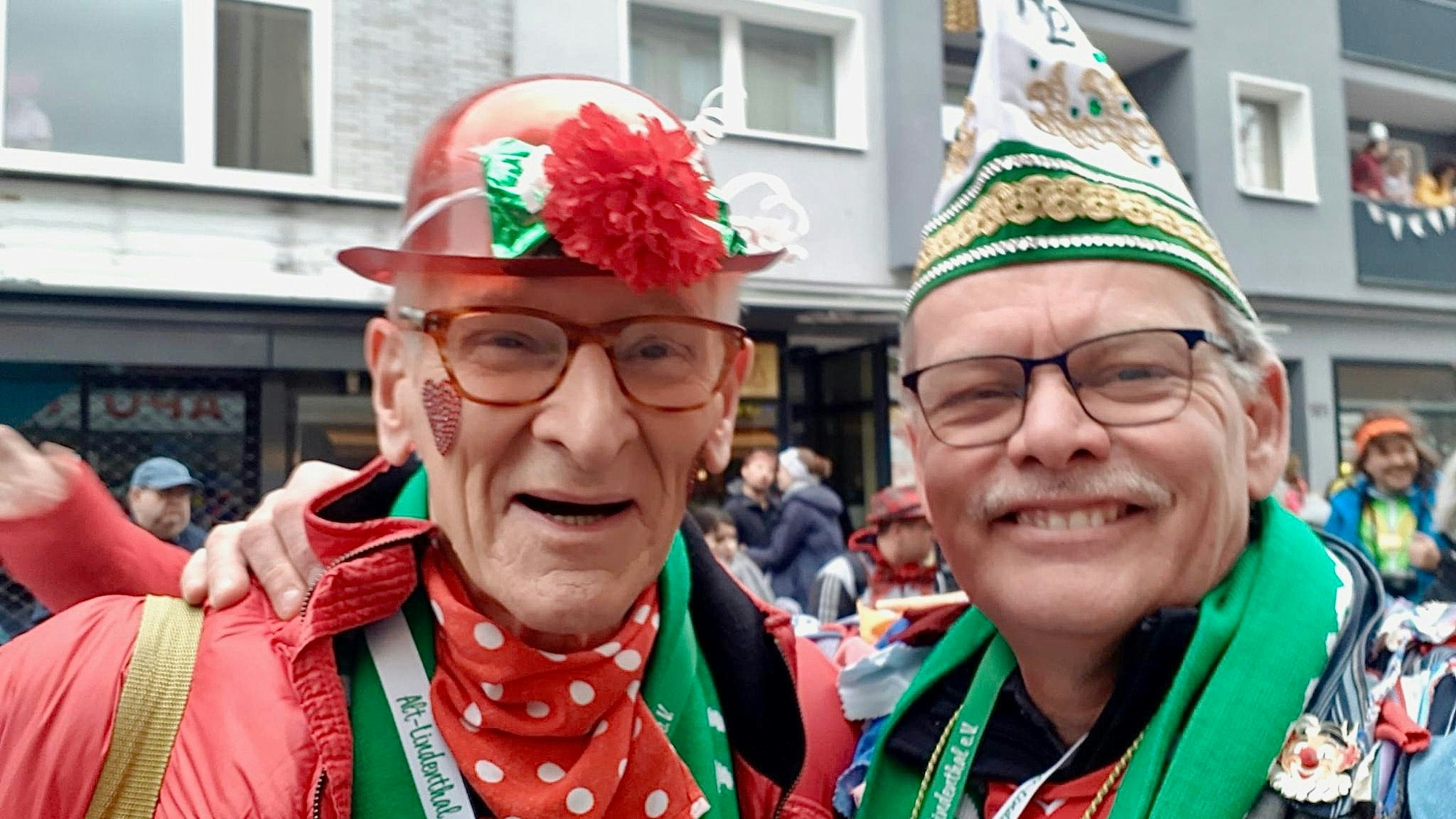 Zwei ältere Männer im Kostüm stehen nebeinander.