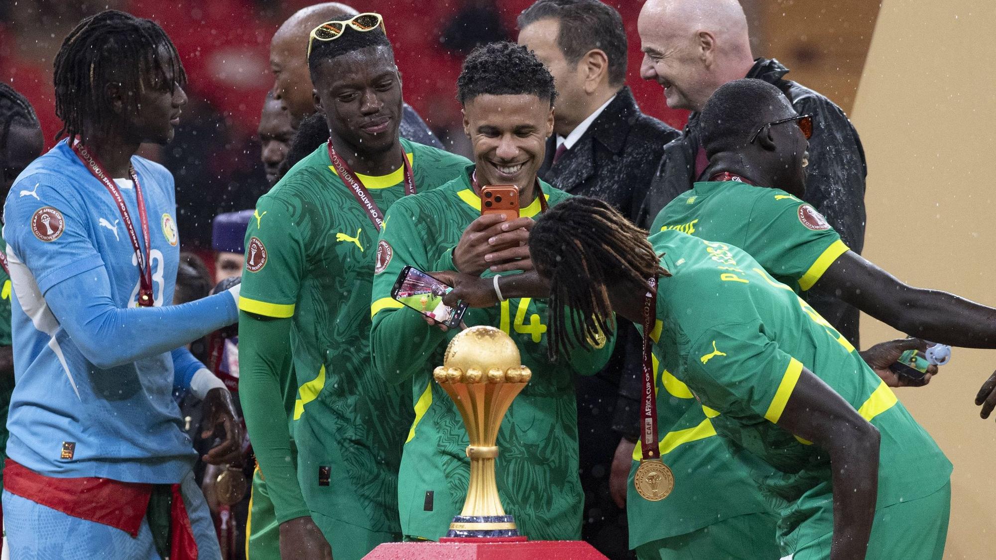 Ismail Jakobs fotografiert die Titel-Trophäe. Der Kölner wurde mit dem Senegal Afrikameister.