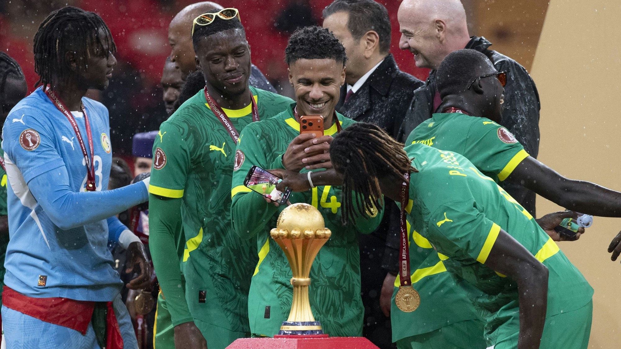 Ismail Jakobs fotografiert die Titel-Trophäe. Der Kölner wurde mit dem Senegal Afrikameister.