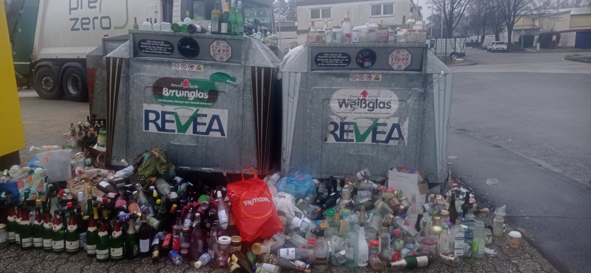 Glasflaschen stehen vor dem Sammelcontainer in Gronau