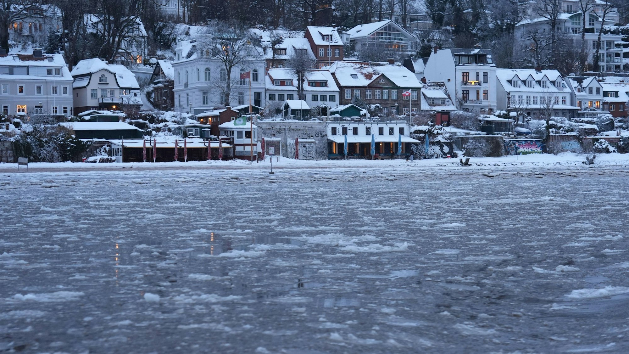 Blick am frühen Morgen von einer Hafenfähre auf die mit Eisschollen bedeckte Elbe bei Ovelgönne.