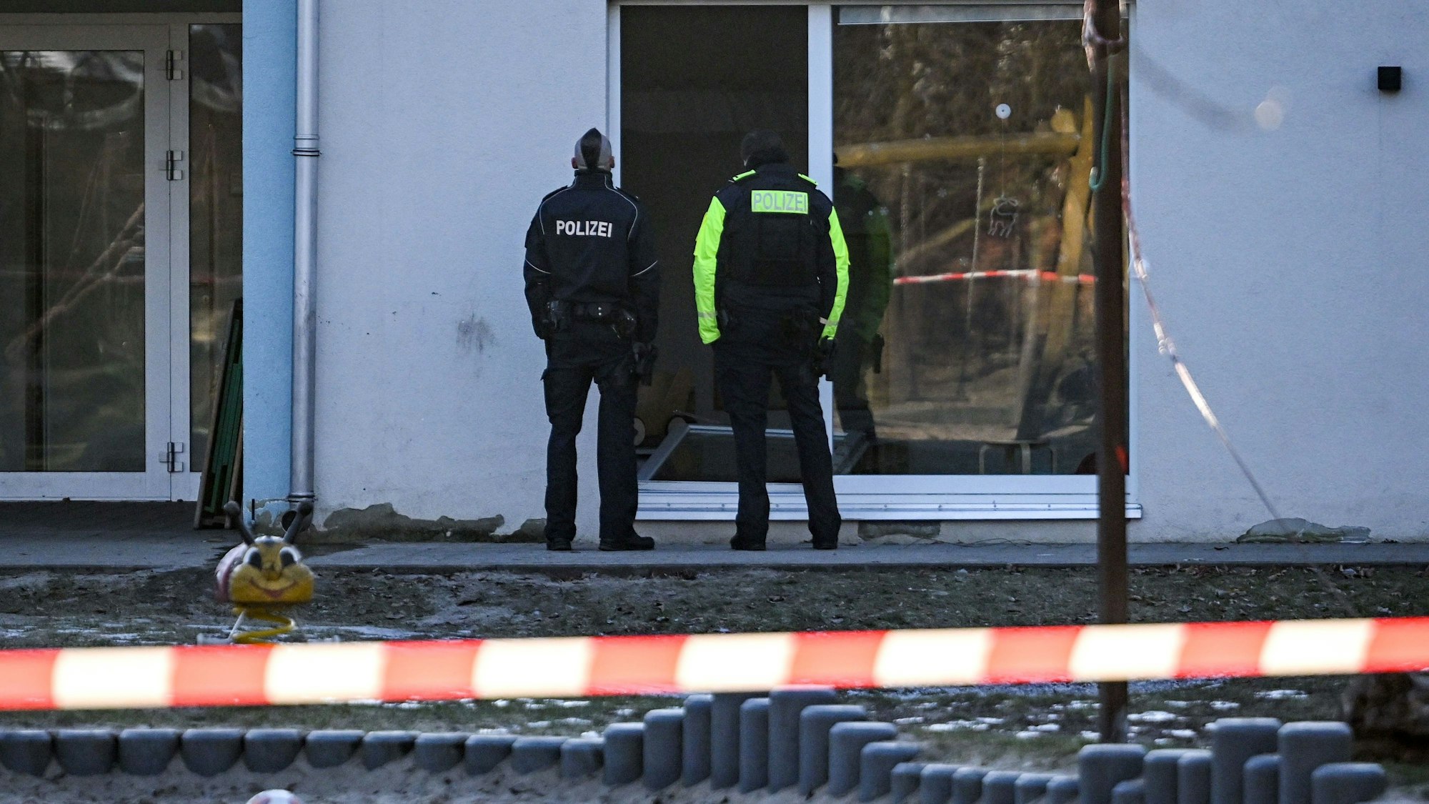 Zwei Polizisten stehen vor einer Kindertagesstätte in Niederschöneweide. Dort ist ein Kind gestorben.