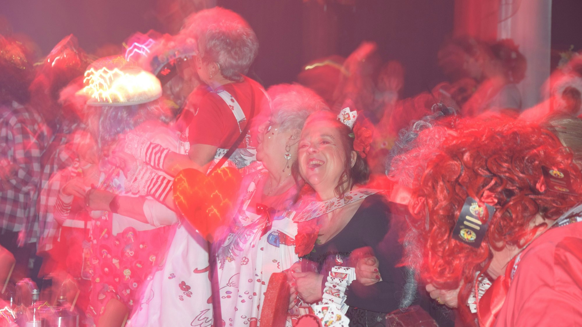 Frauen in Kostümen schunkeln lachend.