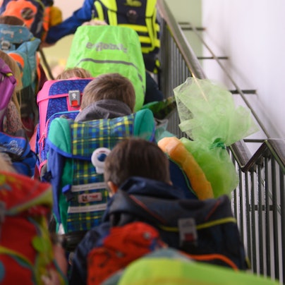 Grundschüler einer ersten Klasse begeben sich an ihrem ersten Schultag durchs Treppenhaus der Schule in ihr Klassenzimmer.
