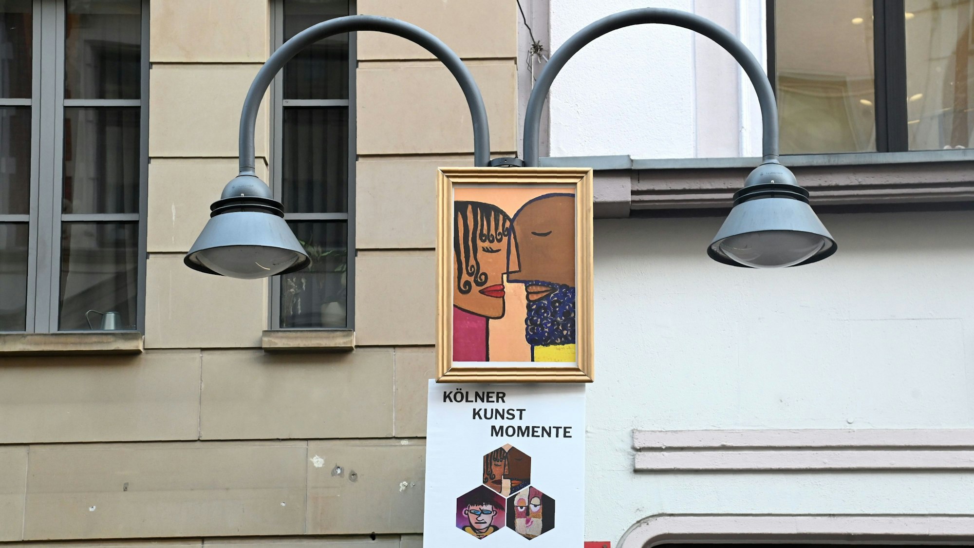 20.01.2026 Köln. "Kölner Kunst Momente": Mit Moderator Thomas Hackenberg (alias TThomas Von Klettenberg ), Jean Nejadi (weiße Jacke ) und Lucie Albrecht . Kunstwerke (Fratzen) von mehreren Künstlern auf A1-Plakaten werden an Laternenkronen auf der Ehrenstraße angebracht. Initiator ist Parfümerie Möltgen auf der Ehrenstraße. Foto: Alexander Schwaiger