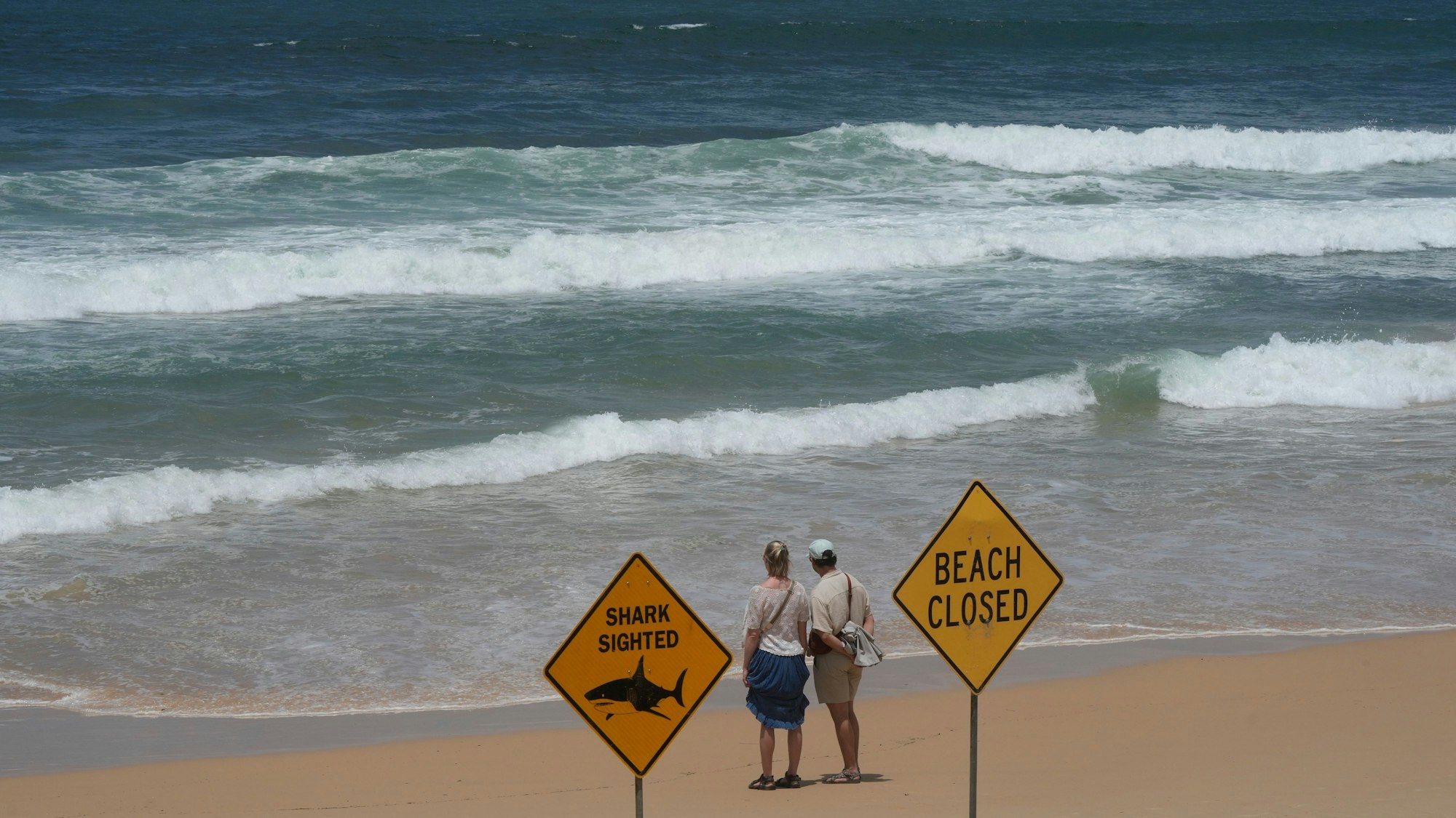 Ein Paar blickt am North Steyne Beach nach einer Reihe von Hai-Angriffen in Sydney auf das Meer.