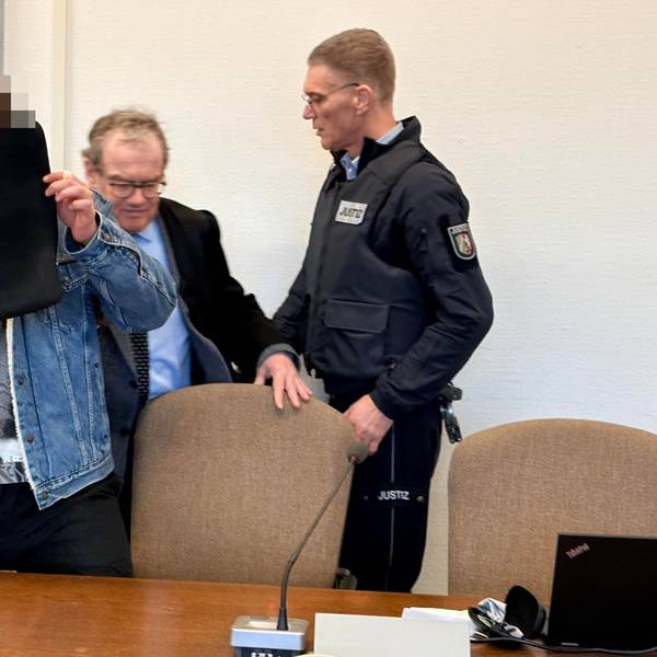 Der Angeklagte mit seinem Verteidiger Lukas Pieplow und einem Wachtmeister beim Prozessauftakt im Kölner Landgericht
