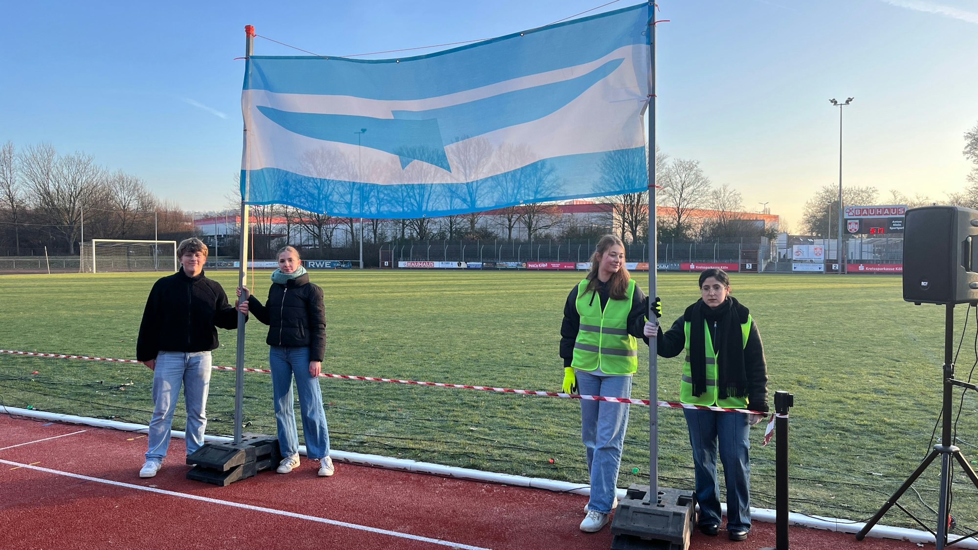 Zur Staatsgründung wurde die Staatsflagge mit einem stilisierten Logo der Schule entrollt.