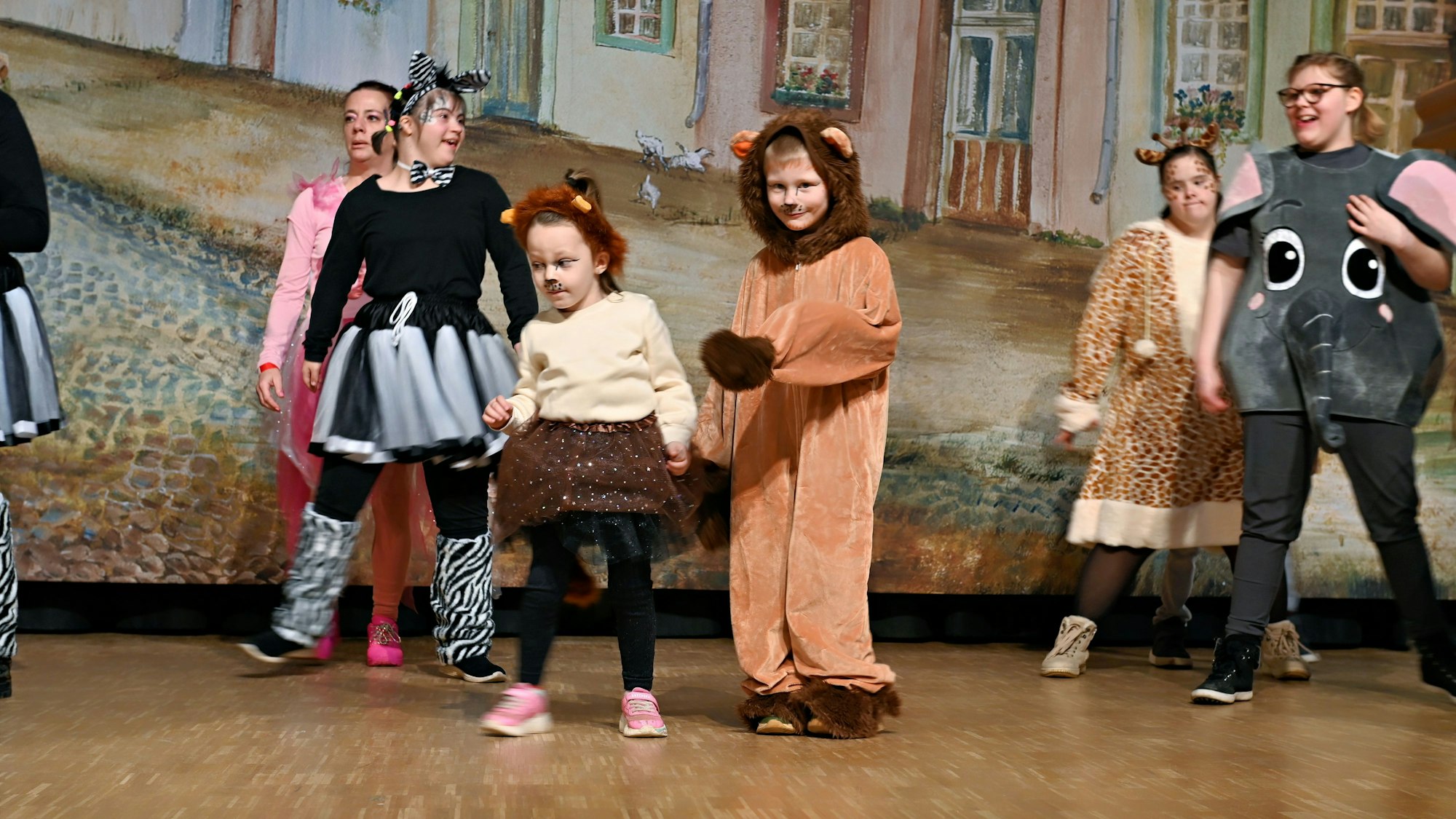Eine Gruppe Kinder tritt in Tierkostümen auf einer Bühne auf.