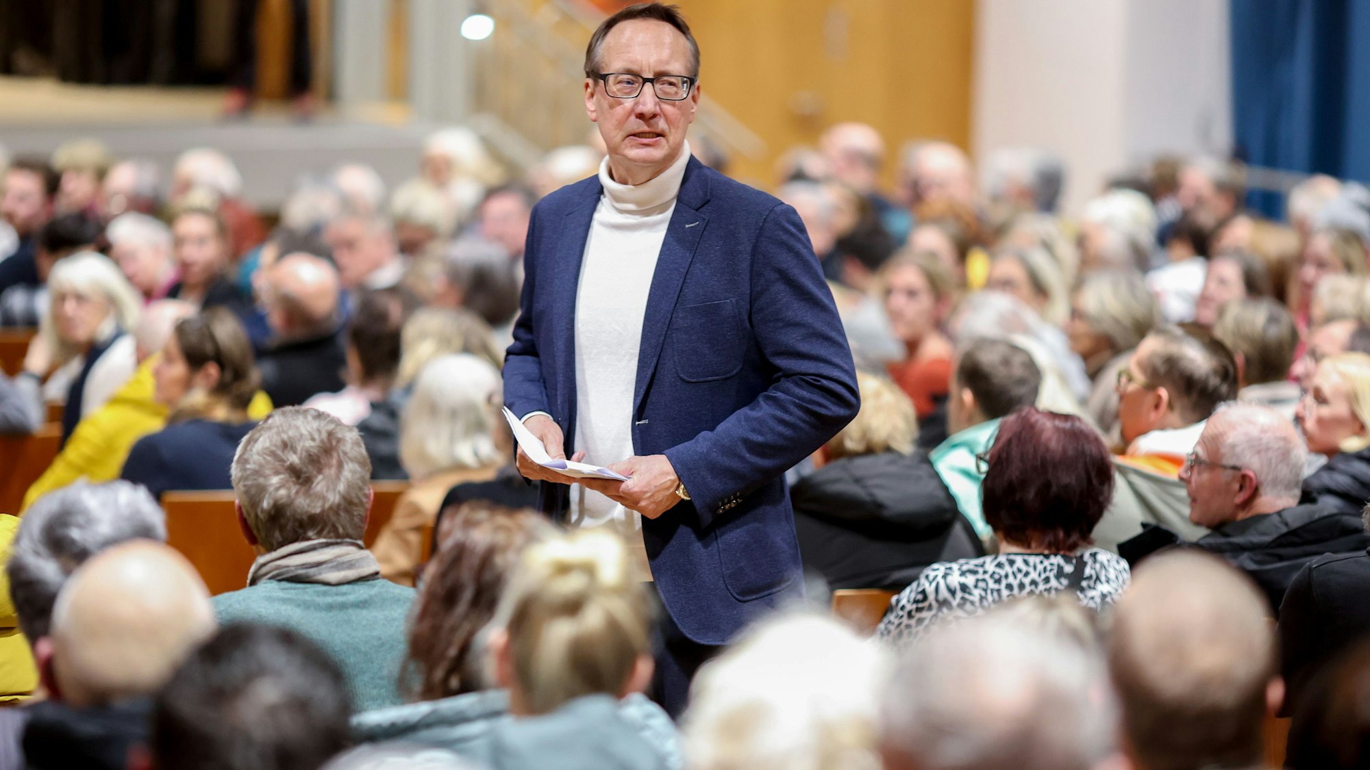 Andreas Zittlau, Vorstandsvorsitzender der IG Pantaleonsviertel, spricht bei der Anwohnerversammlung der IG Pantaleonsviertel zum Thema ‚Widerstand gegen geplantes Drogenkonsumzentrum im Wohnviertel‘ in der Aula des Berufskollegs am Perlengraben in Köln. (Archivbild)