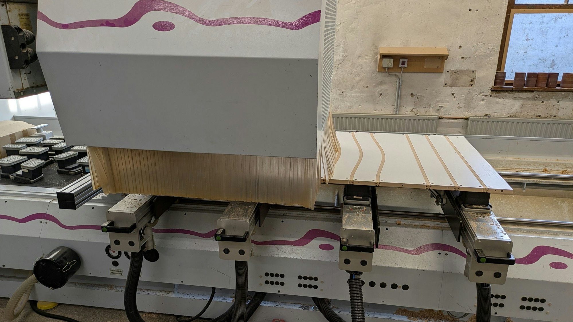 Eine computergesteuerte Maschine bearbeitet eine MDF-Platte.