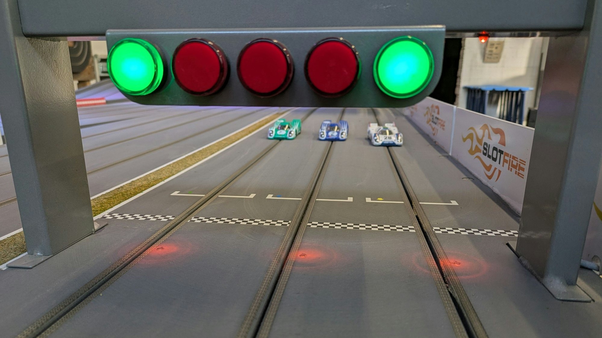 Drei Porsche 917 K-Modelle stehen am Start der Slotfire-Bahn.