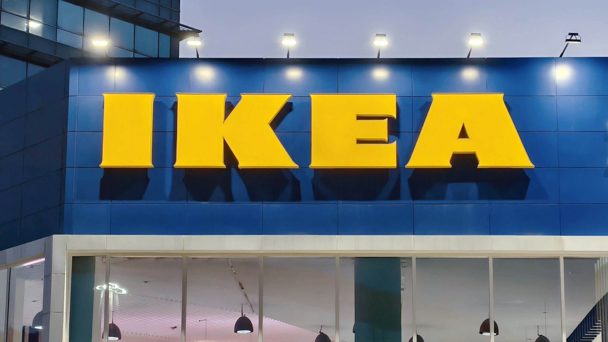 Der Schriftzug an einer Ikea-Filiale wird von Strahlern beleuchtet.