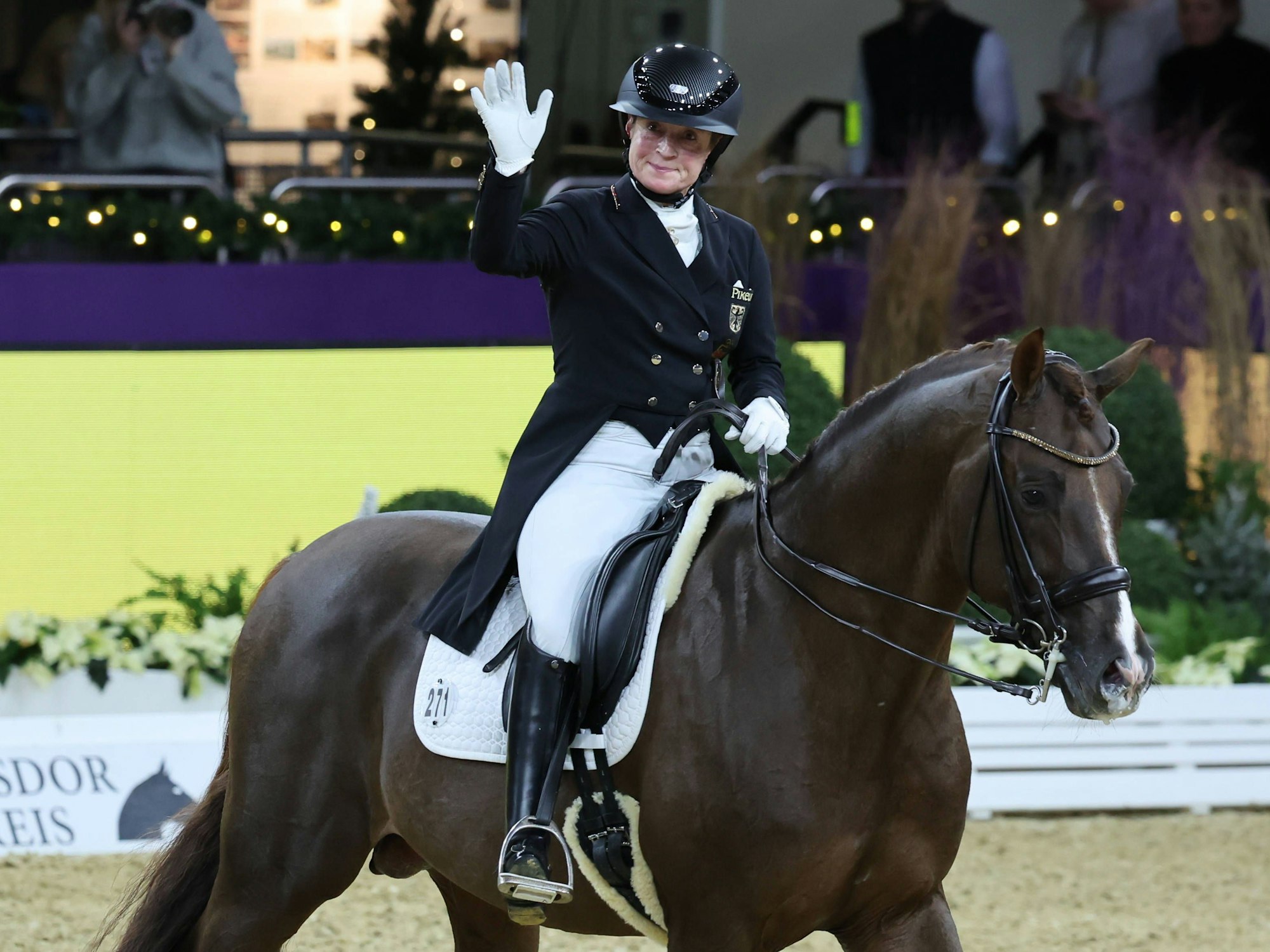 Isabell Werth ist auf dem Pferd Viva Gold zu sehen und winkt ins Publikum.