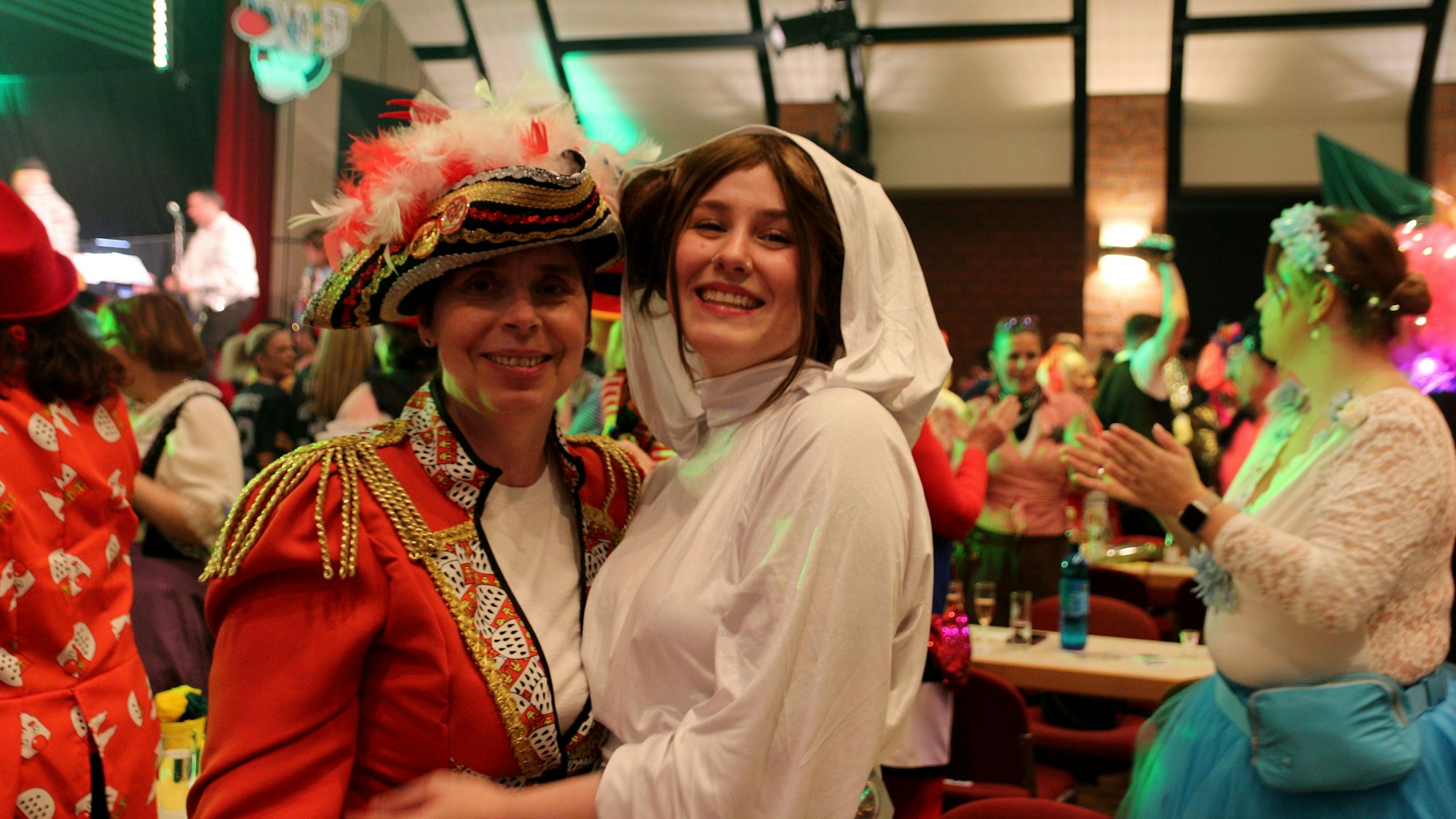 Das Bild zeigt zwei kostümierte Frauen, eine in rotem Sakko mit Piratenhut, eine zweite mit weißer Kapuzenrobe.