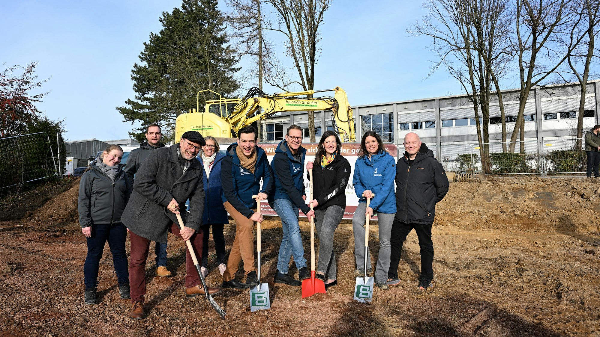 Eine Gruppe von Leuten steht in der Baugrube.