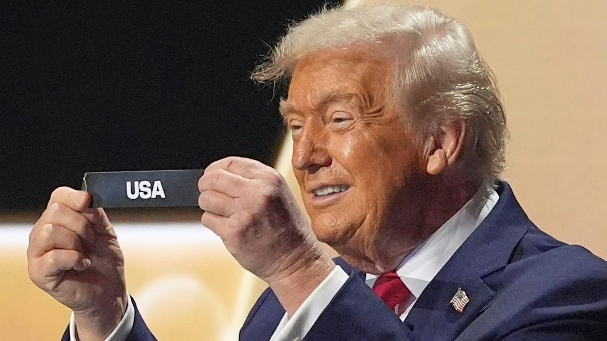 US-Präsident Donald Trump lächelt, nachdem er bei der Auslosung einen Zettel mit dem Wort „USA“ aus einem Topf gezogen hat.