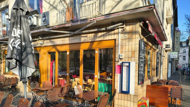 Vor einem Restaurant sind Stühle und Tische zu sehen.