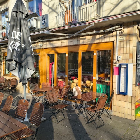 Vor einem Restaurant sind Stühle und Tische zu sehen.