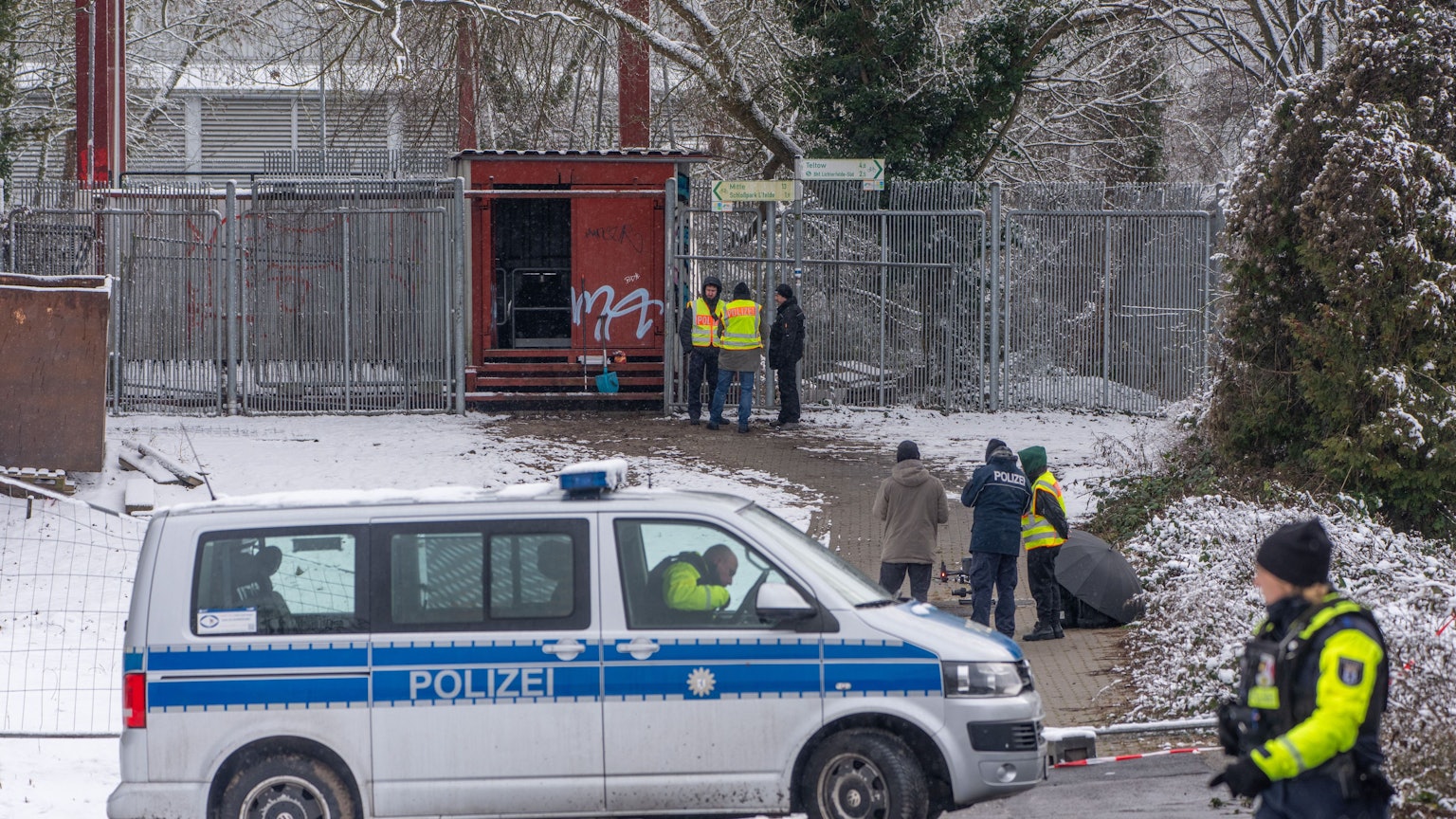 Einsatzkräfte der Polizei stehen an der Brandstelle einer Kabelbrücke vor dem Kraftwerk Lichterfelde am Teltowkanal.
