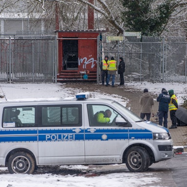 Einsatzkräfte der Polizei stehen an der Brandstelle einer Kabelbrücke vor dem Kraftwerk Lichterfelde am Teltowkanal.