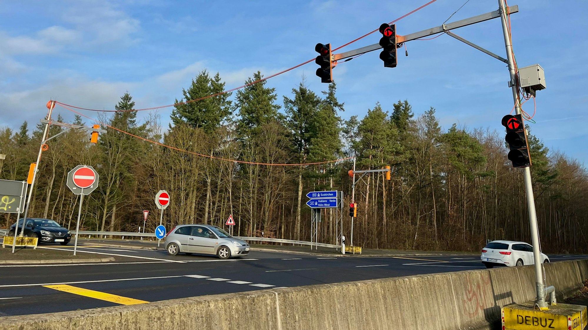Zu sehen ist eine Ampelanlage an einer Straße.