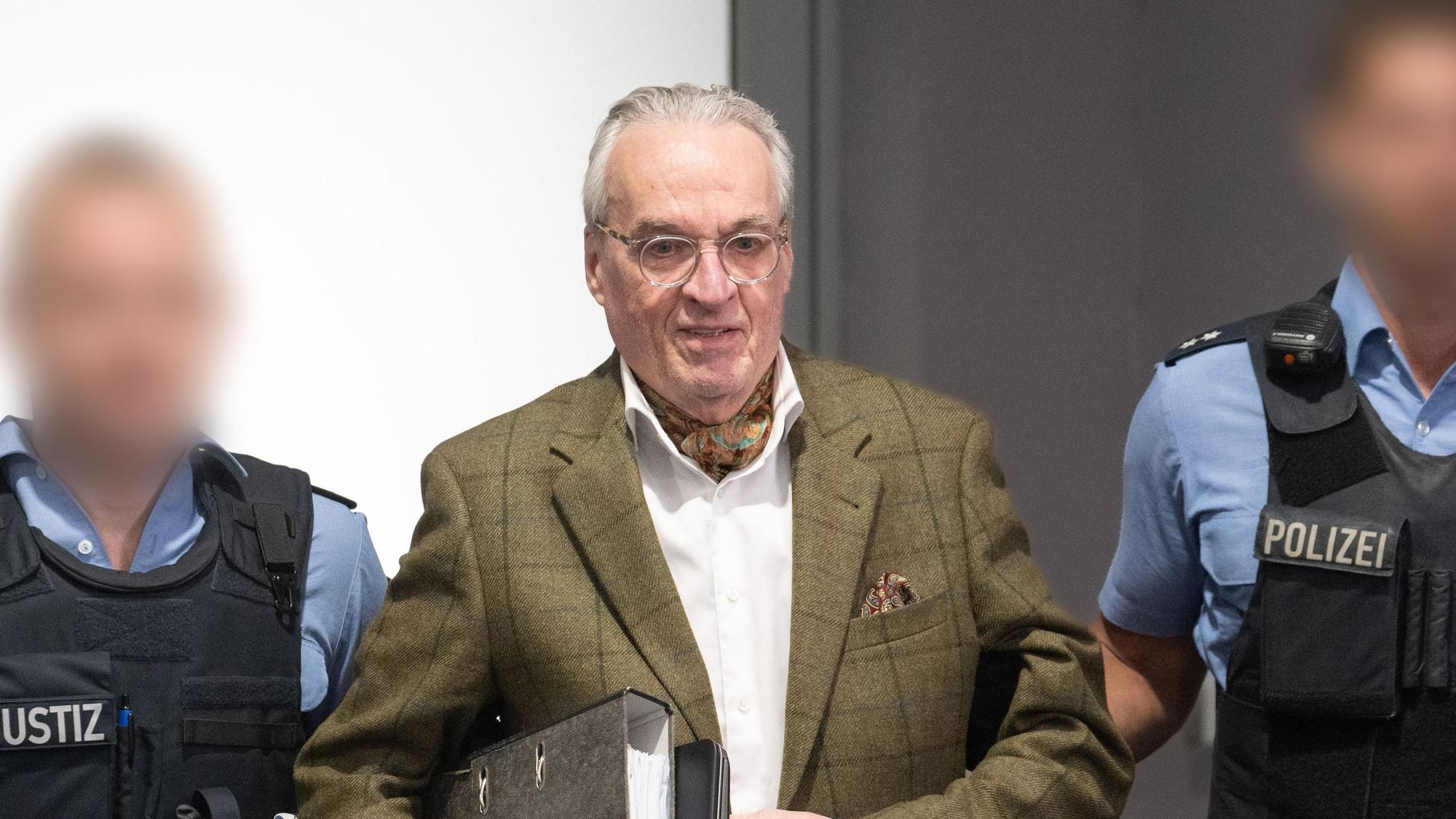 Das Bild zeigt den Hauptangeklagten Heinrich der XIII. Prinz Reuß (M) bei seiner Ankunft im Verhandlungssaal im Oberlandesgericht Frankfurt, Außenstelle im Stadtteil Sossenheim. Die Bundesanwaltschaft legt den neun Angeklagten zur Last, Mitglied in einer terroristischen Vereinigung gewesen zu sein. Foto: Boris Roessler/dpa Pool/dpa