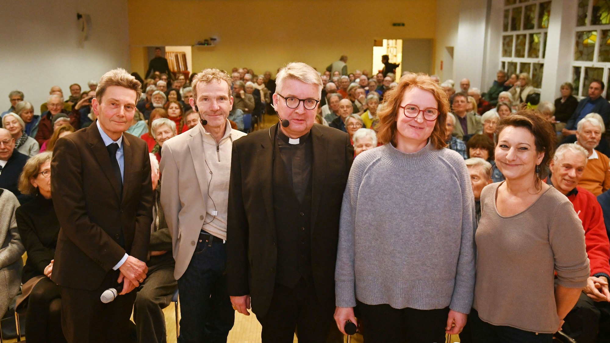 Fünf Menschen lächeln in die Kamera.