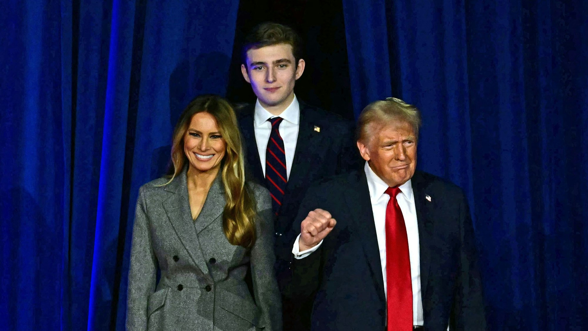 Melania Trump, Barron Trump und Donald Trump betreten eine Bühne.