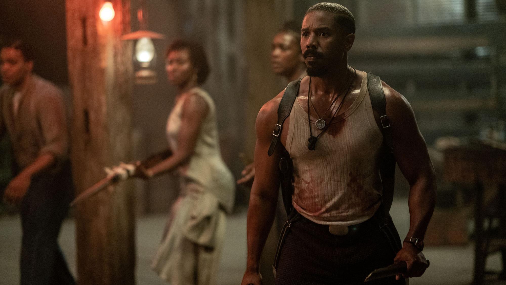 Michael B. Jordan steht mit blutigem Unterhemd und Messer in der Hand Vampiren gegenüber.