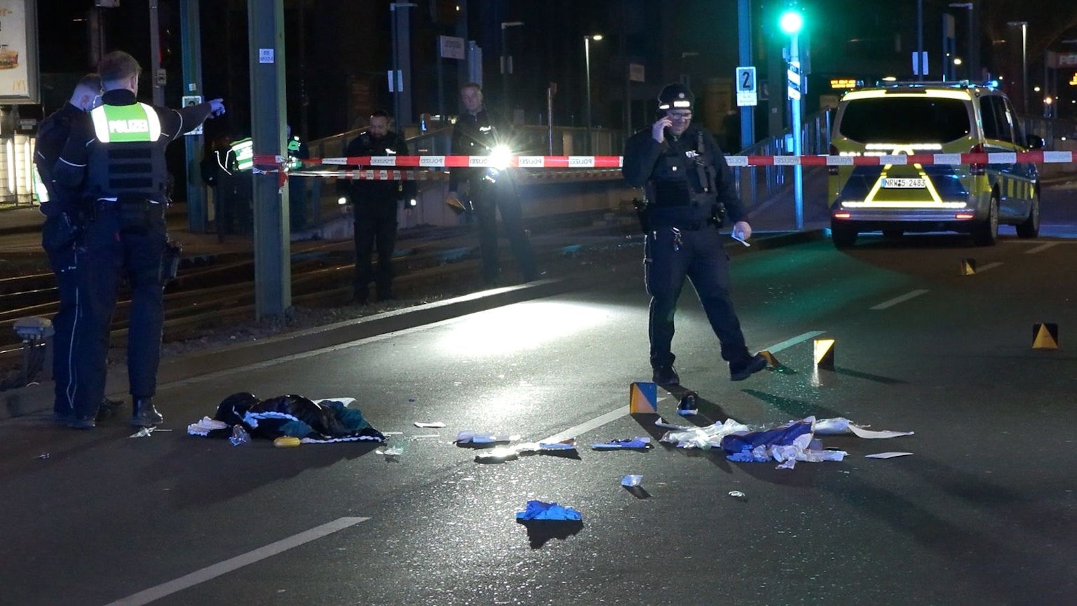 Das Bild zeigt Einsatzkräfte der Polizei, die einen mit Flatterband abgesperrten Tatort auf einer Straße untersuchen. Nach Schüssen in der Dortmunder Nordstadt ist ein Mann gestorben. Foto: Justin Brosch/dpa