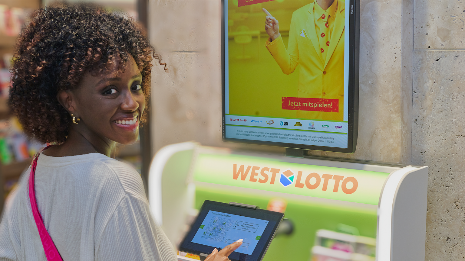 Eine Frau gibt ihren Tipp für das Spiel LOTTO 6aus49 an einem WestLotto Stand ab.