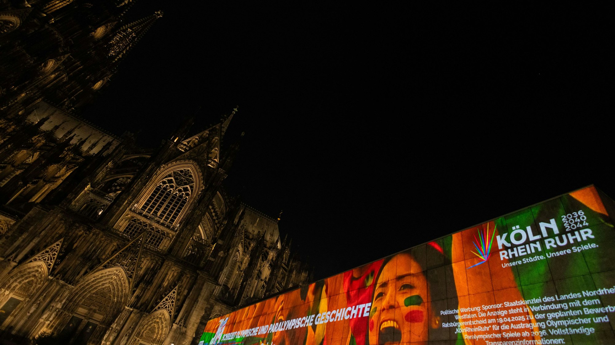 Eine Projektion auf dem Römisch-Germanischen Museum neben dem Dom am Roncalliplatz wirbt vor dem Bürgerentscheid am 19. April für die Spiele Köln-Rhein-Ruhr.