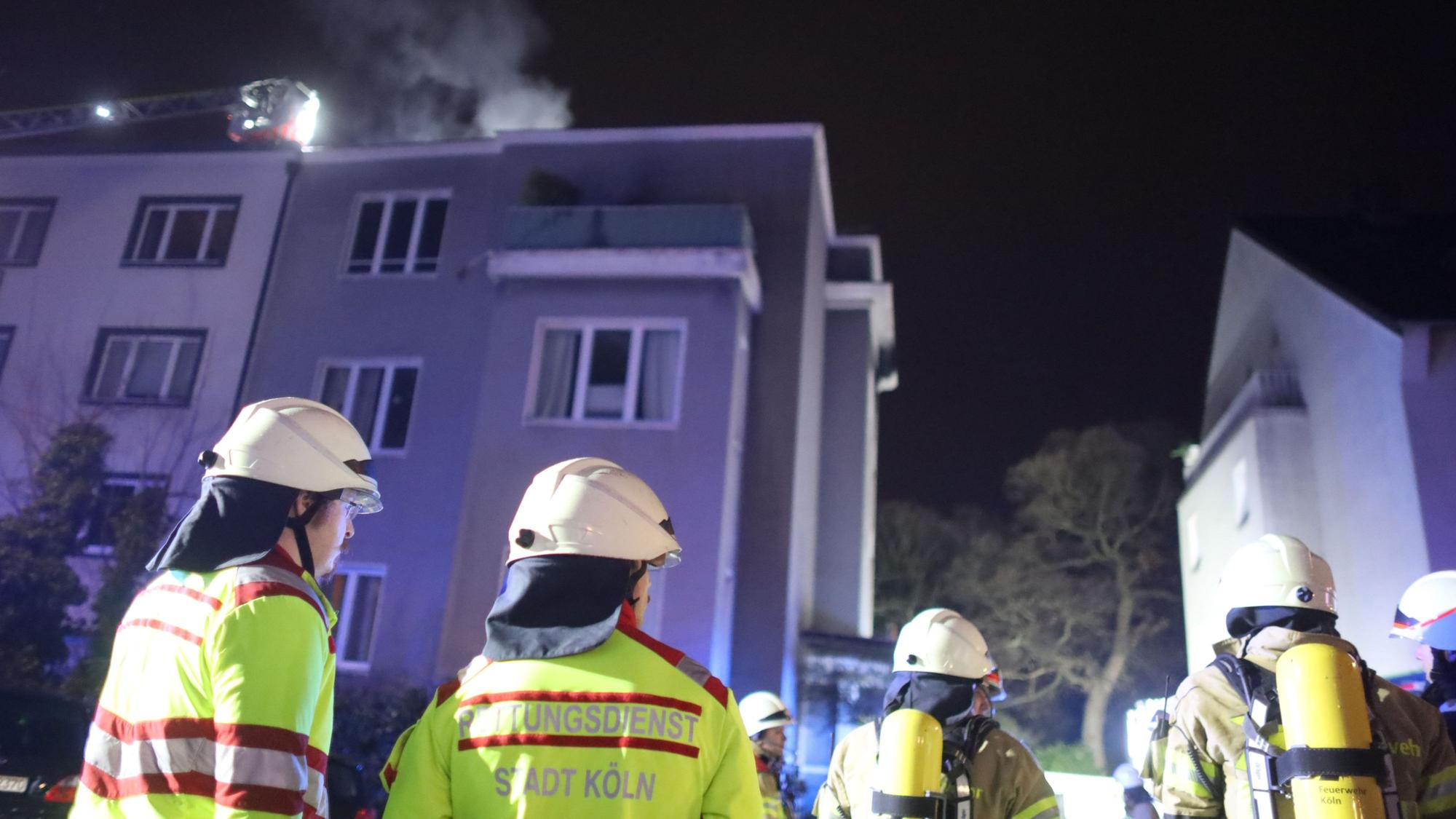Einsatzkräfte der Kölner Feuerwehr vor dem brennenden Haus im Weyertal.